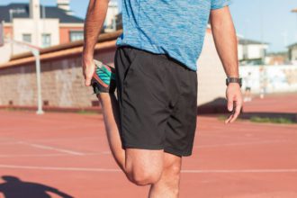 Adult athlete stretching the muscles of his legs, quadriceps and calves to avoid serious injury.