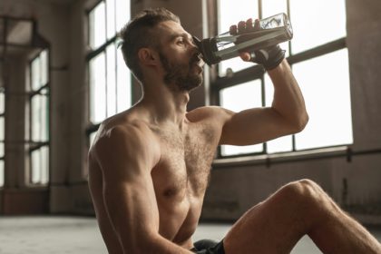 Muscular man drinking water after workout